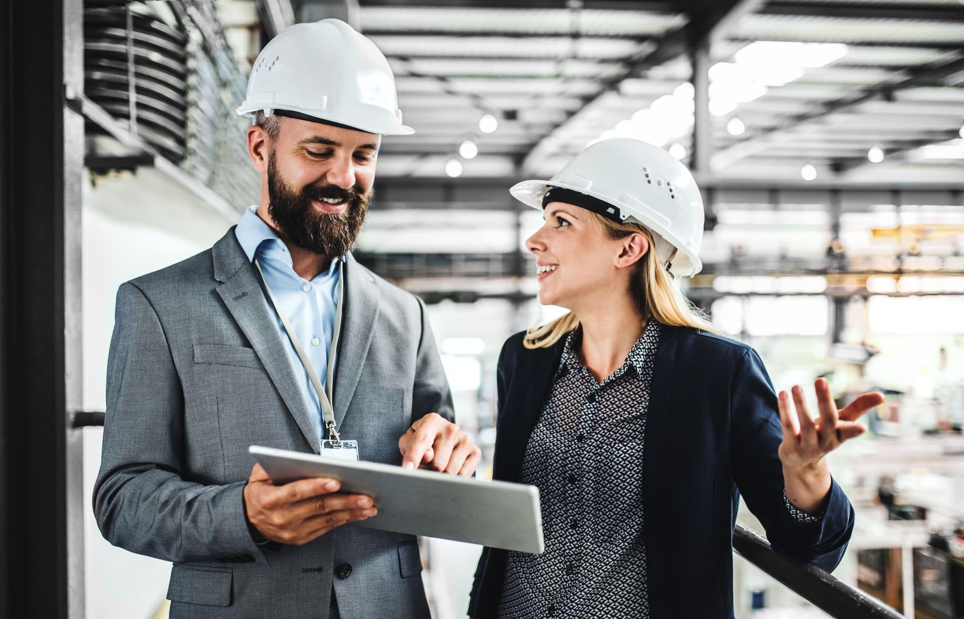 Engenheiros industriais operando um tablet no chão de fábrica